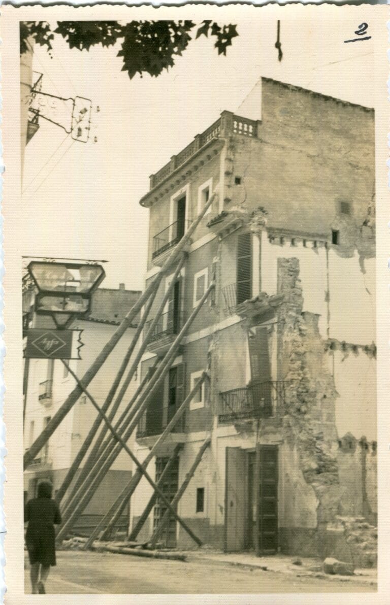Imatge en color sèpia d'un edifici del carrer Aníbal d'Eivissa destruit per un bombardeig